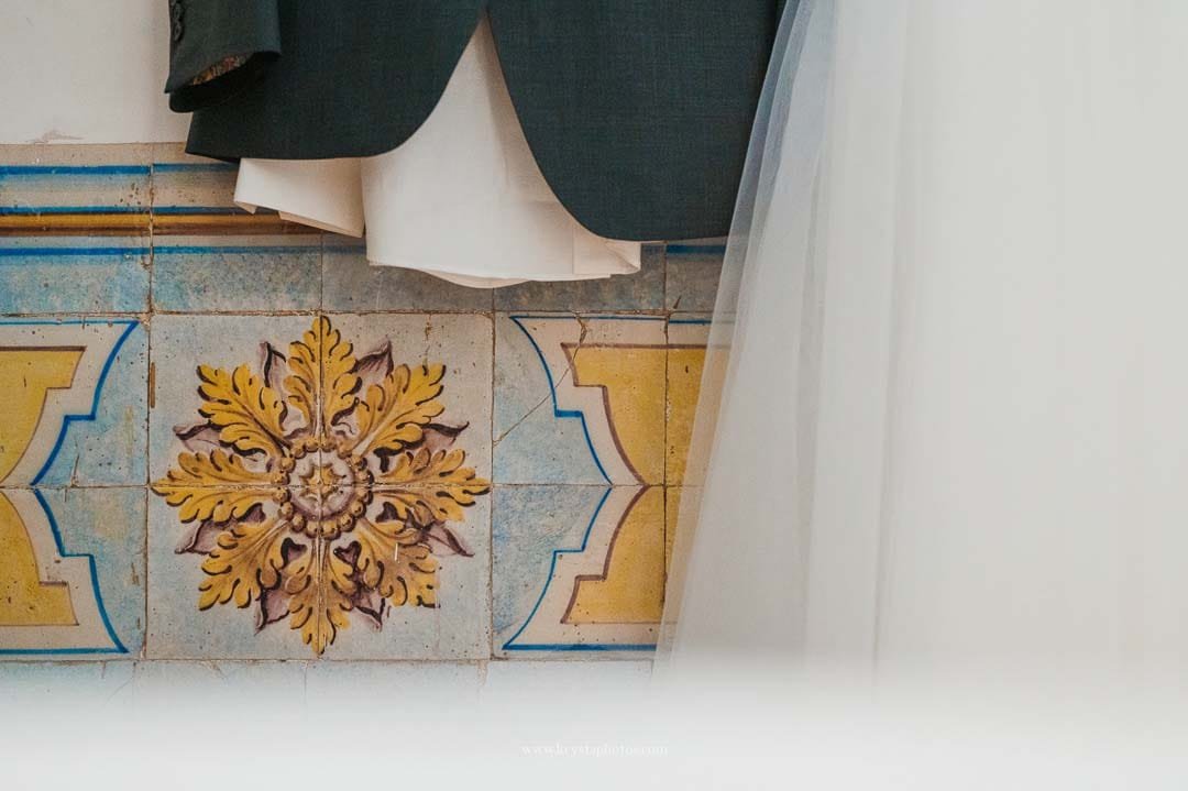 Detail of the groom’s attire against traditional Portuguese blue tiles in a Lisbon mansion during an intimate wedding.