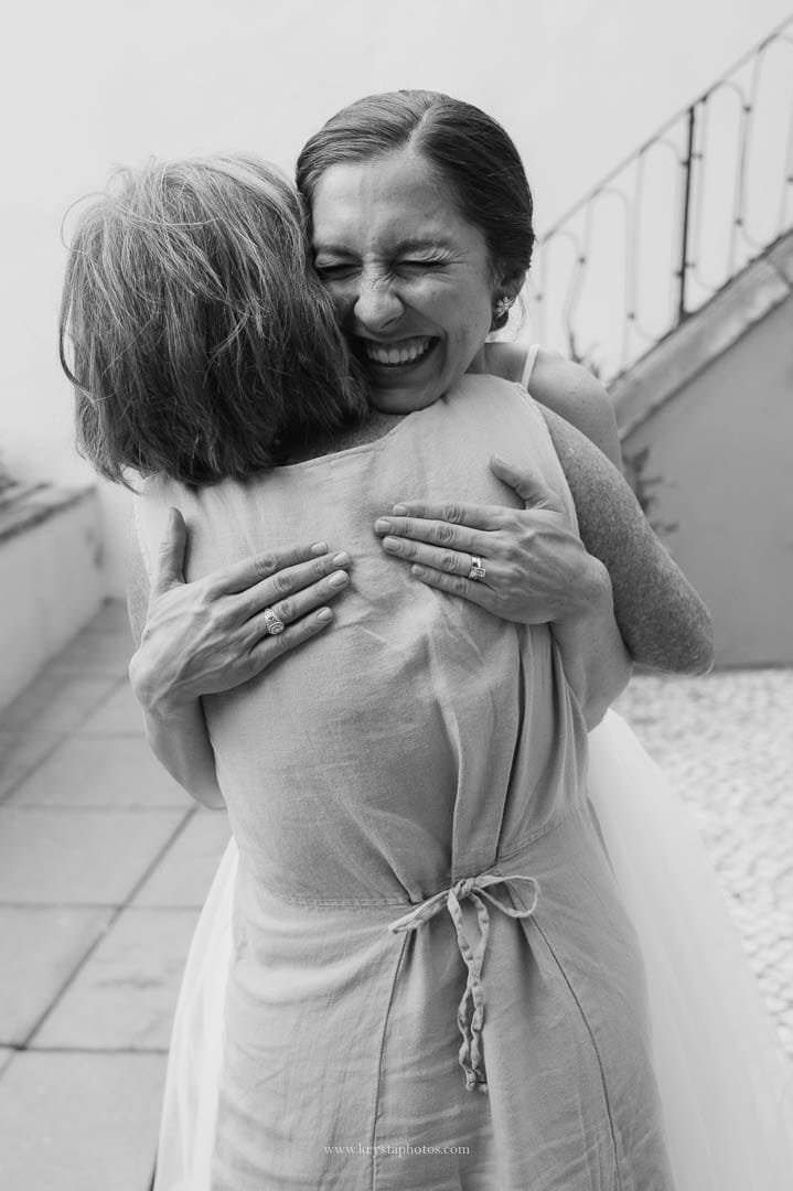 Bride and groom sharing smiles and hugs with family on a terrace in Lisbon after their intimate micro-wedding ceremony.