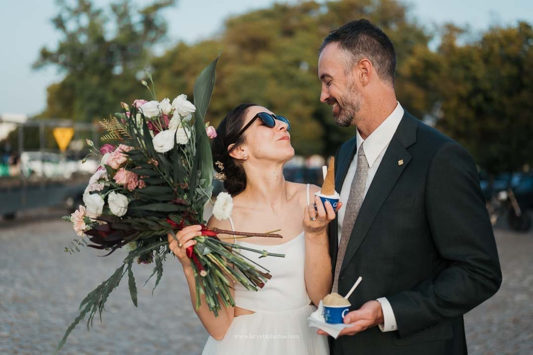 Bride and groom sharing ice cream together before boarding a sailboat during their intimate Lisbon micro-wedding.