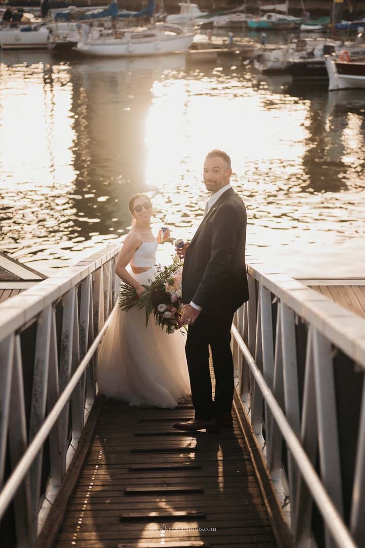 Bride and groom boarding a sailboat on the Tagus River at sunset during their intimate Lisbon micro-wedding.