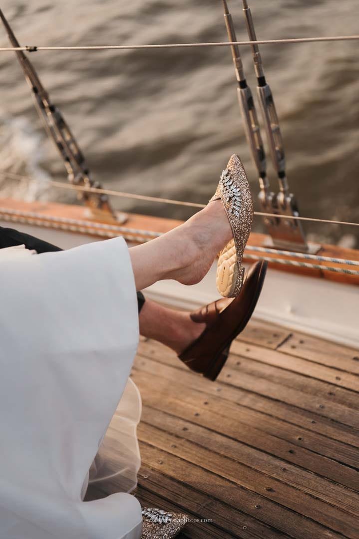 Bride and groom enjoying a cheese and cold cuts board with bubbly on a sailboat during their sunset cruise in Lisbon.