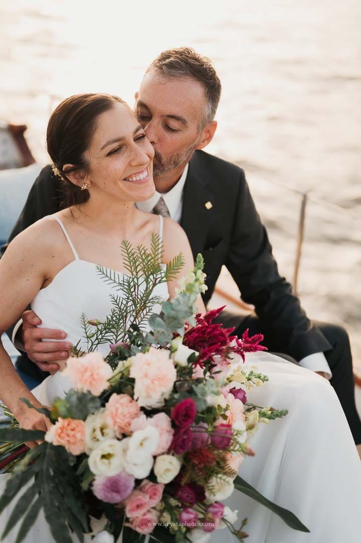Bride and groom enjoying a cheese and cold cuts board with bubbly on a sailboat during their sunset cruise in Lisbon.