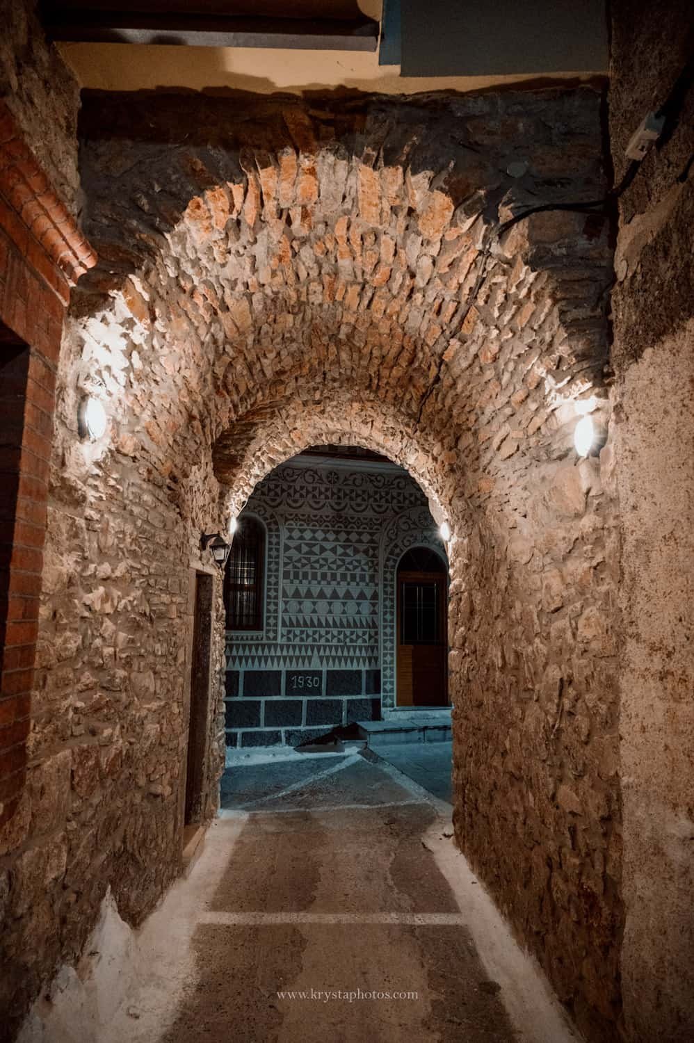 Couple strolling the narrow streets of Lemnos island, Greece being completely relaxed and enjoying summer holidays together.