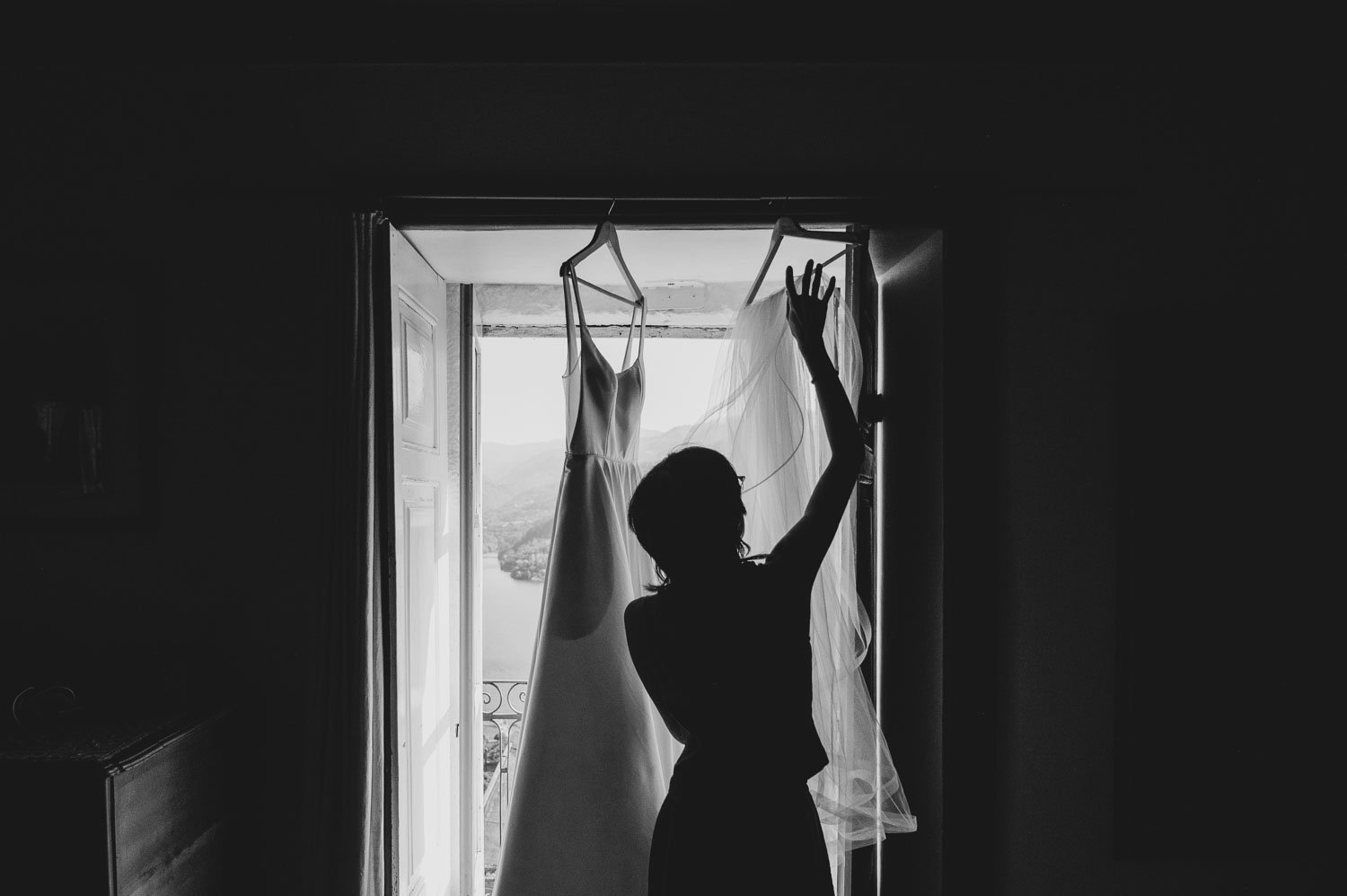 Bride adjusting her veil next to her wedding dress during bridal preparations in the Douro Valley