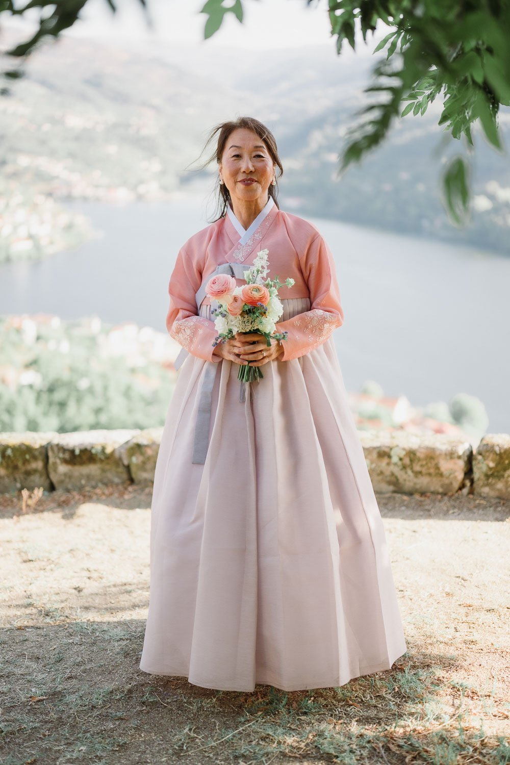 The bride and her mother wearing a traditional Korean hanbok overlooking the Douro River during their intimate Douro Valley wedding.