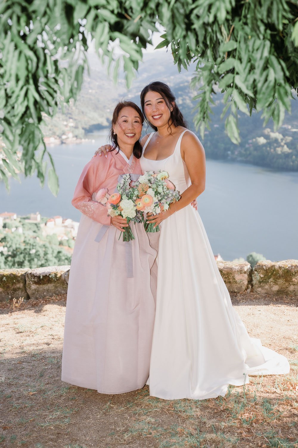 The bride and her mother wearing a traditional Korean hanbok overlooking the Douro River during their intimate Douro Valley wedding.