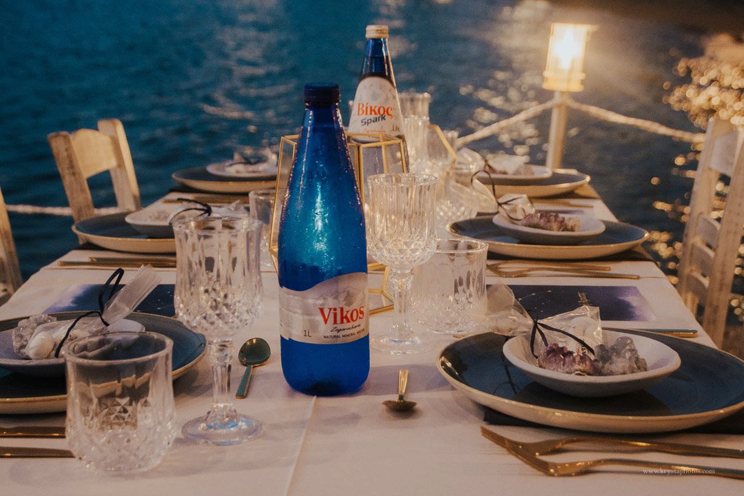 Candlelit seaside beach wedding dinner in Greece with newlyweds, guests, and live music 