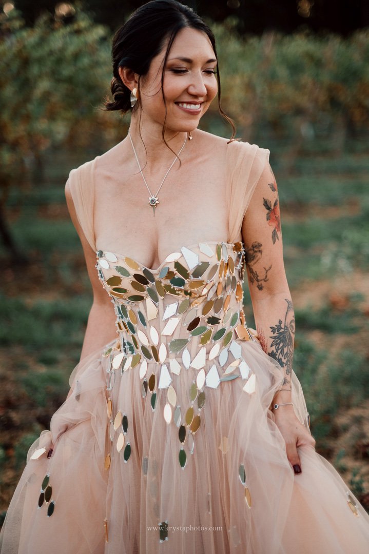 Bride in whimsical blush pink wedding dress posing for stunning portraits in lush Portugal vineyards