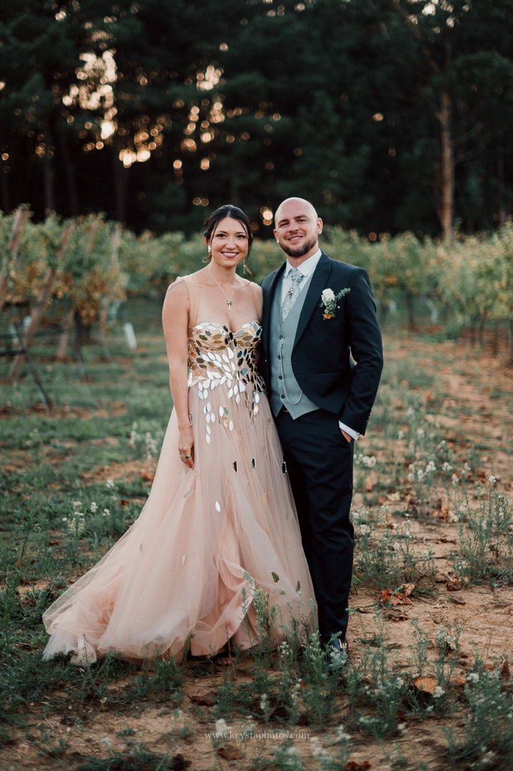 Bride and groom in whimsical wedding attire posing for romantic portraits in Portugal vineyards