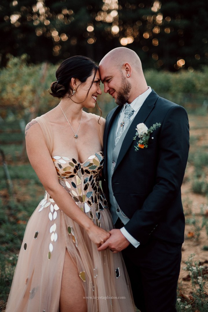 Bride in whimsical blush pink wedding dress posing for stunning portraits in lush Portugal vineyards