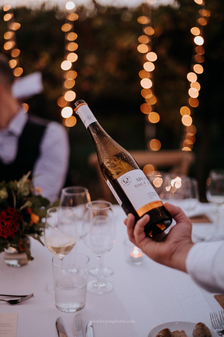 Close-up of Portuguese wine being poured into a glass at a whimsical vineyard wedding reception
