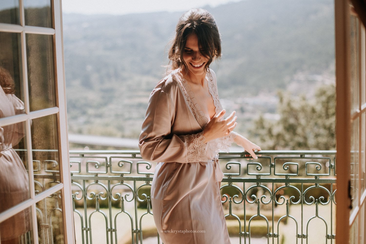 Bride wearing a silk robe during bride preparation for wedding on a European balcony