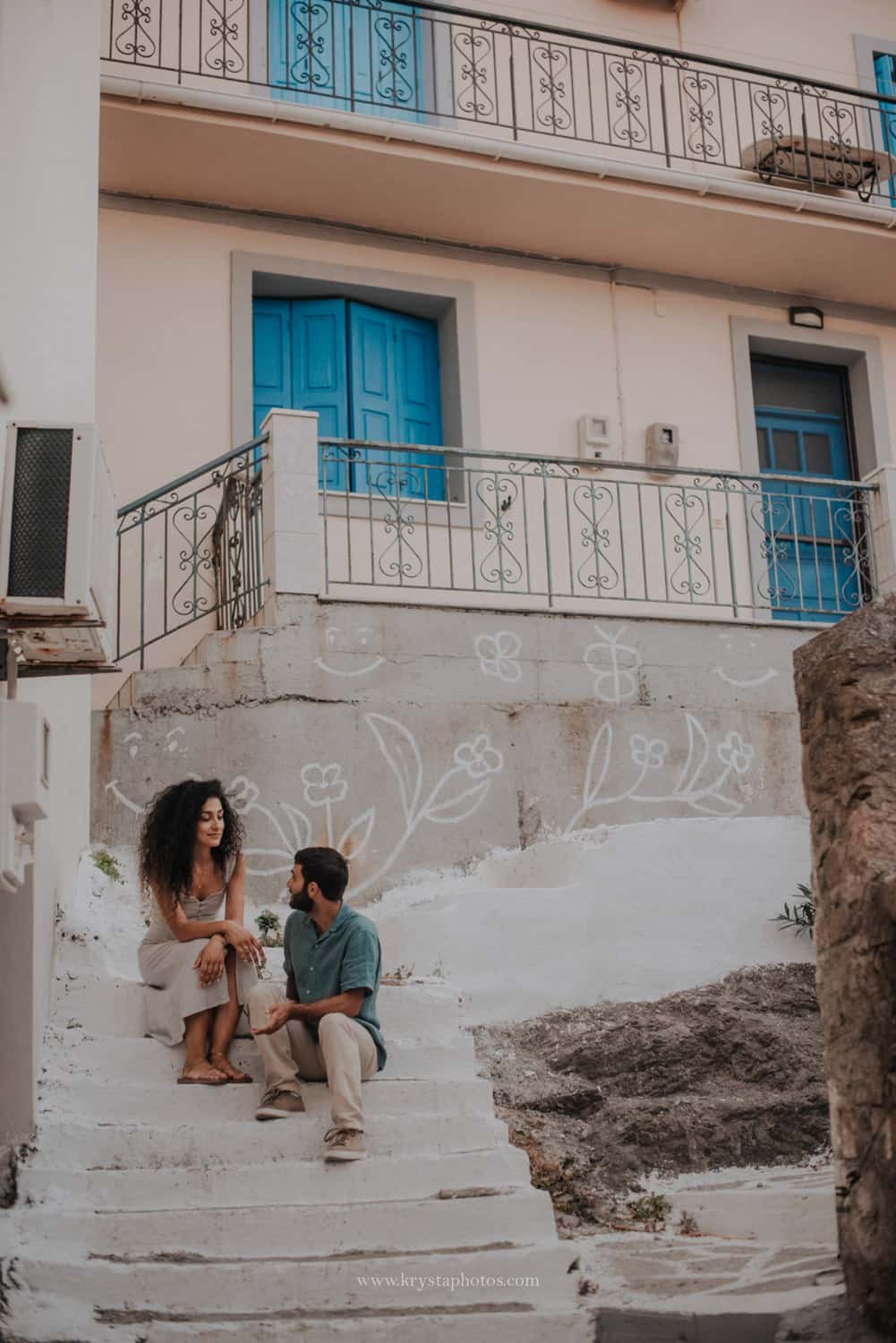Couple strolling the narrow streets of Lemnos island, Greece being completely relaxed and enjoying summer holidays together.