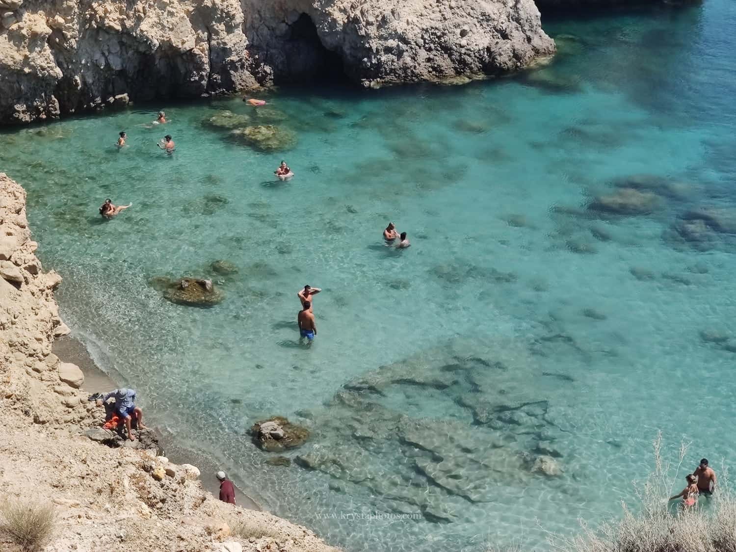 Couple kissing at sunset overlooking the whitewashed village of Myrina, Greece during a romantic engagement session