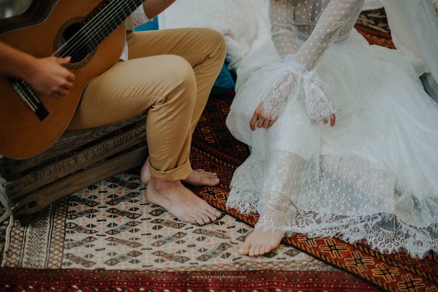 Boho chic wedding editorial detail with guitar and barefoot couple on vintage rug photographed by Portugal wedding photographer