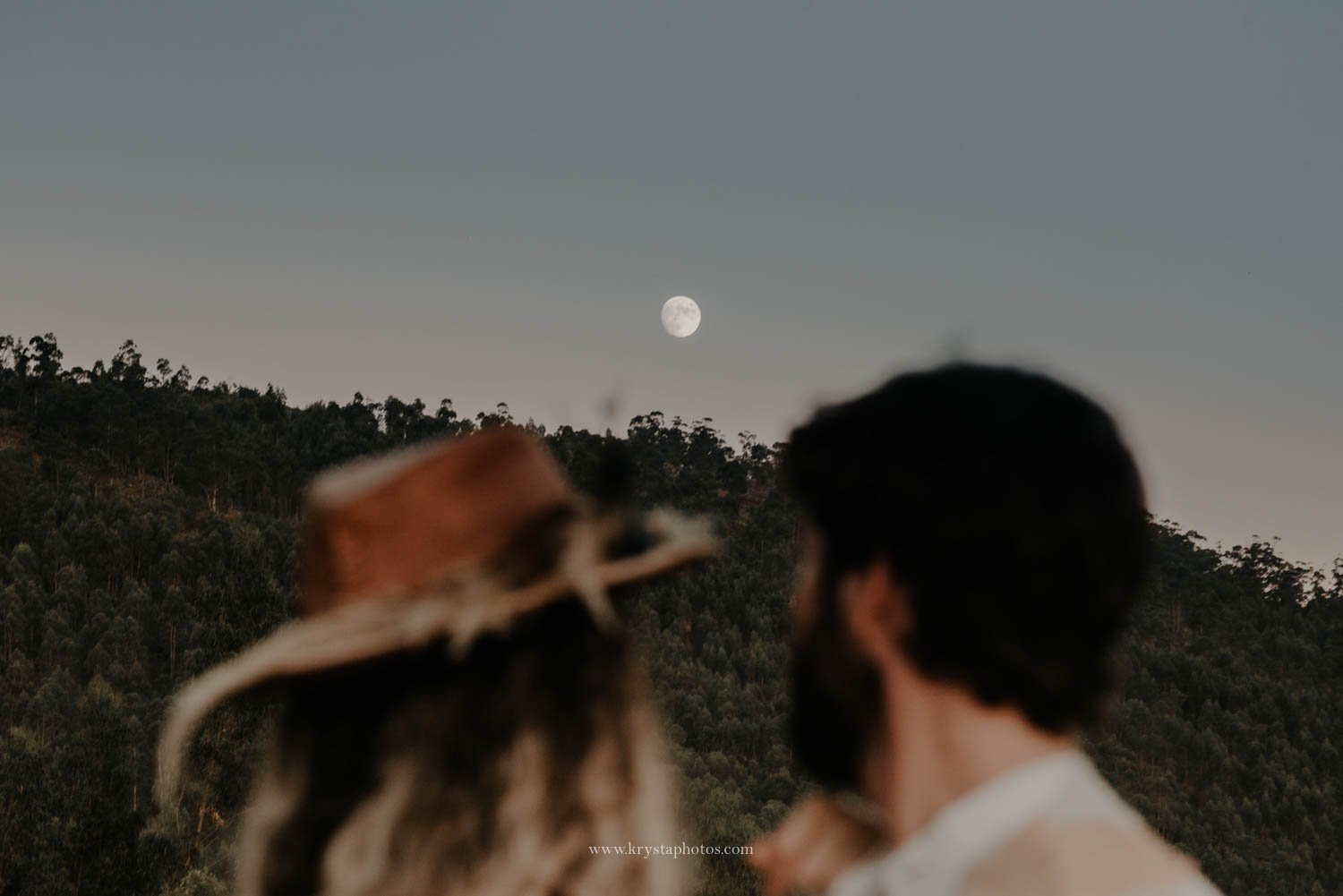 Romantic editorial wedding couple looking at the moon during golden hour in Portugal<br />
