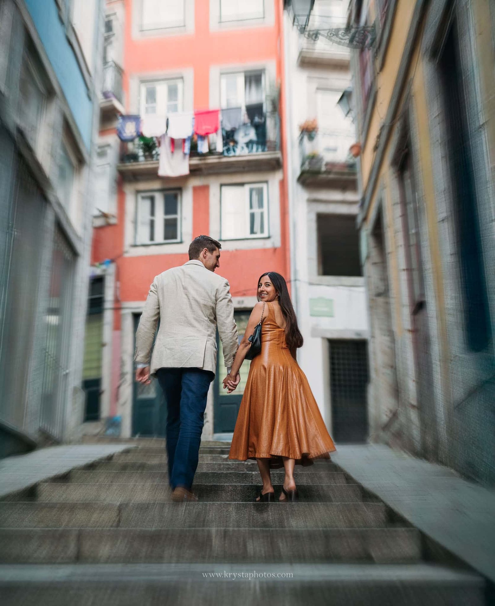 Well-dressed couple during Porto engagement photoshoot, iconic Porto streets and monuments, elegant dress and Prada bag, polished groom