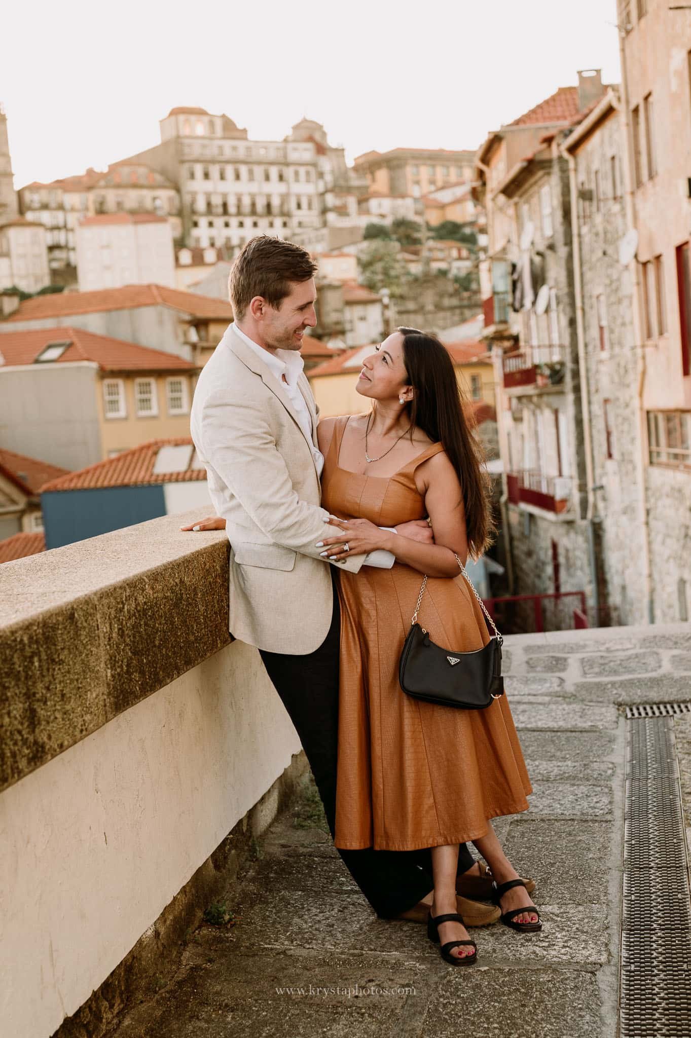 Well-dressed couple during Porto engagement photoshoot, iconic Porto streets and monuments, elegant dress and Prada bag, polished groom