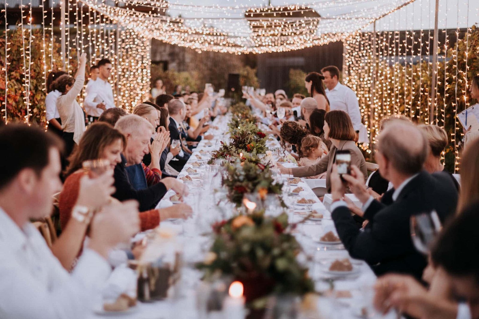 Magical fairy light dinner setup surrounded by vineyards with glowing lightbulbs at a whimsical Portugal wedding