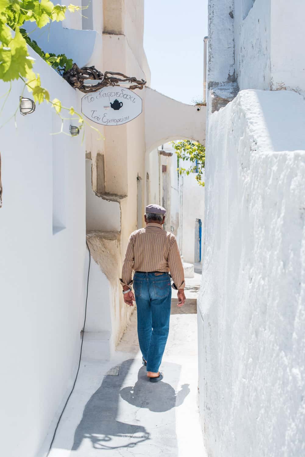 Couple kissing at sunset overlooking the whitewashed village of Myrina, Greece during a romantic engagement session