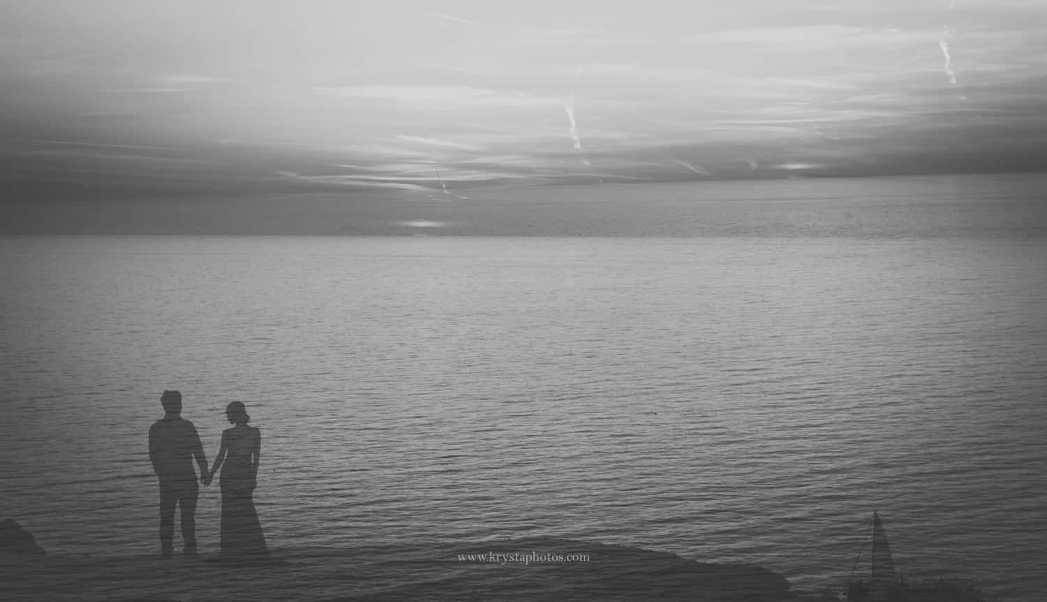 Silhouetted couple holding hands at sunset over the sea in Santorini, Greece, black and white double exposure