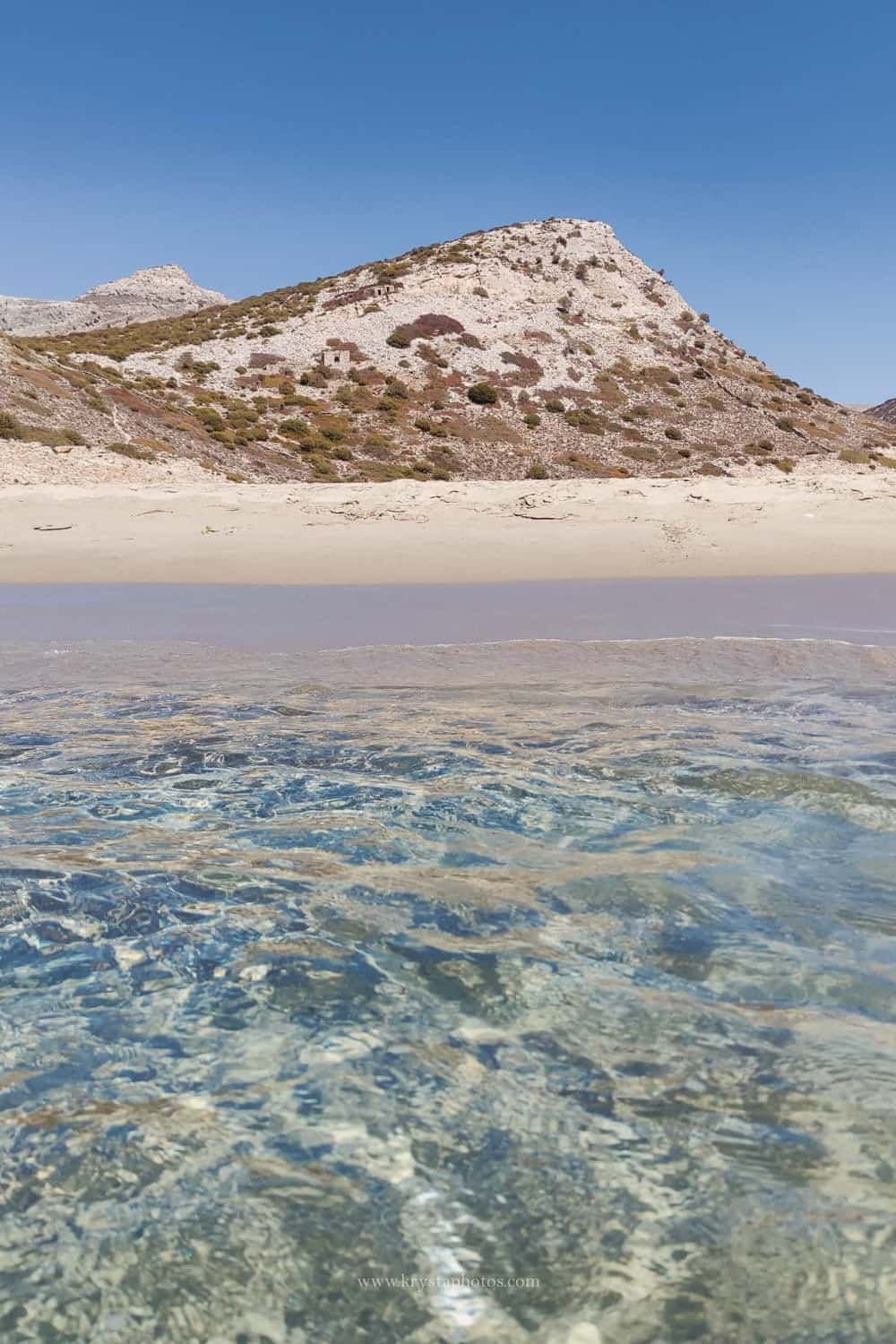 Couple strolling the narrow streets of Lemnos island, Greece being completely relaxed and enjoying summer holidays together.