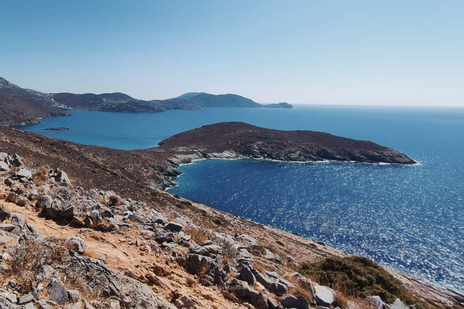 Happy gay couple smiling at each other on a sunny beach in Milos, Greece