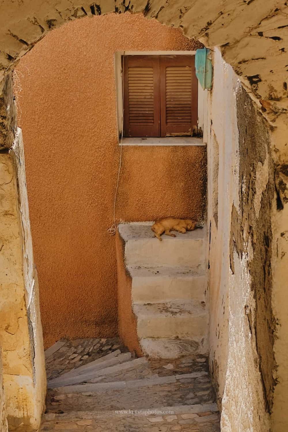 Couple strolling the narrow streets of Lemnos island, Greece being completely relaxed and enjoying summer holidays together.