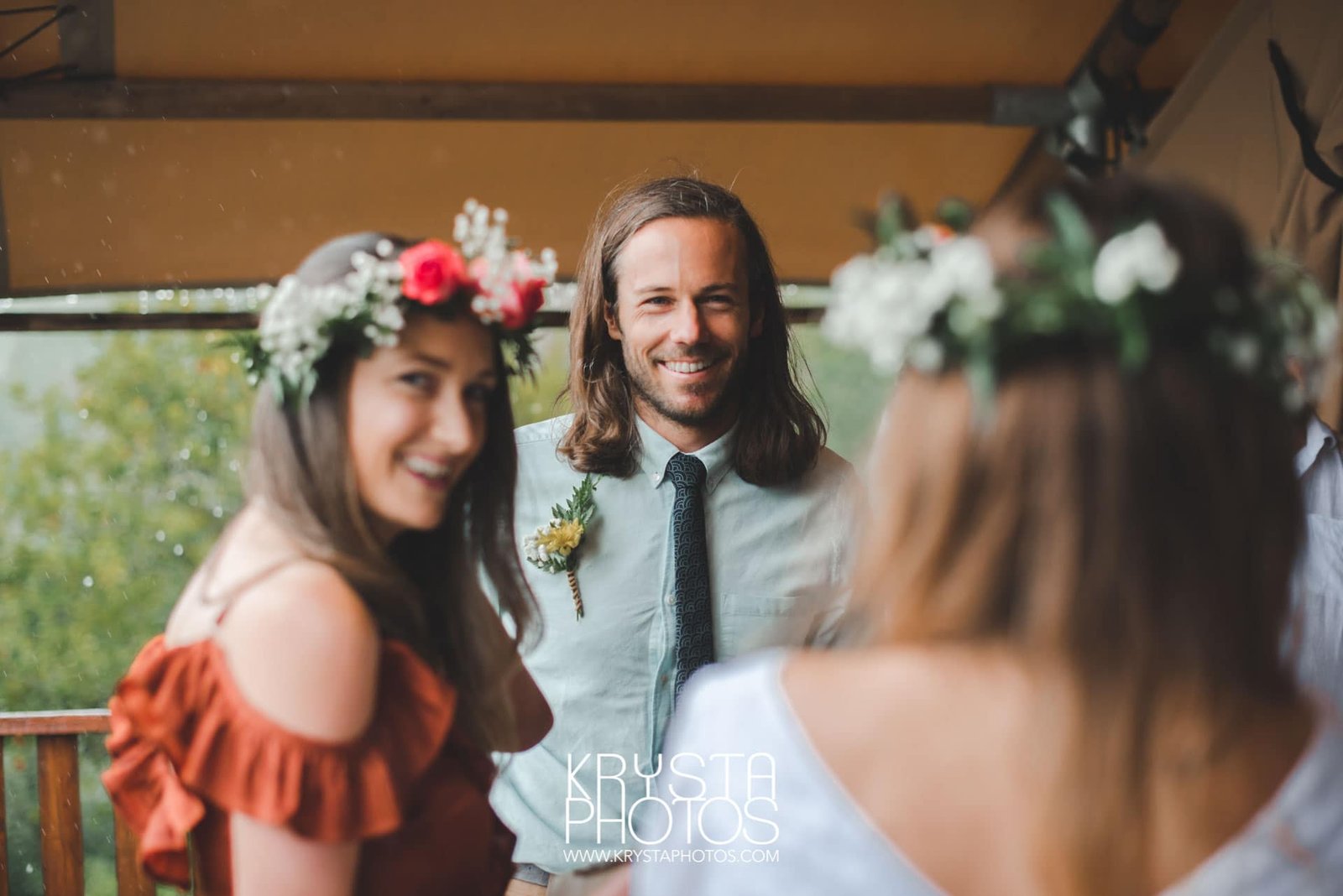 Smiling groom during first look with his bride at a rainy outdoor wedding