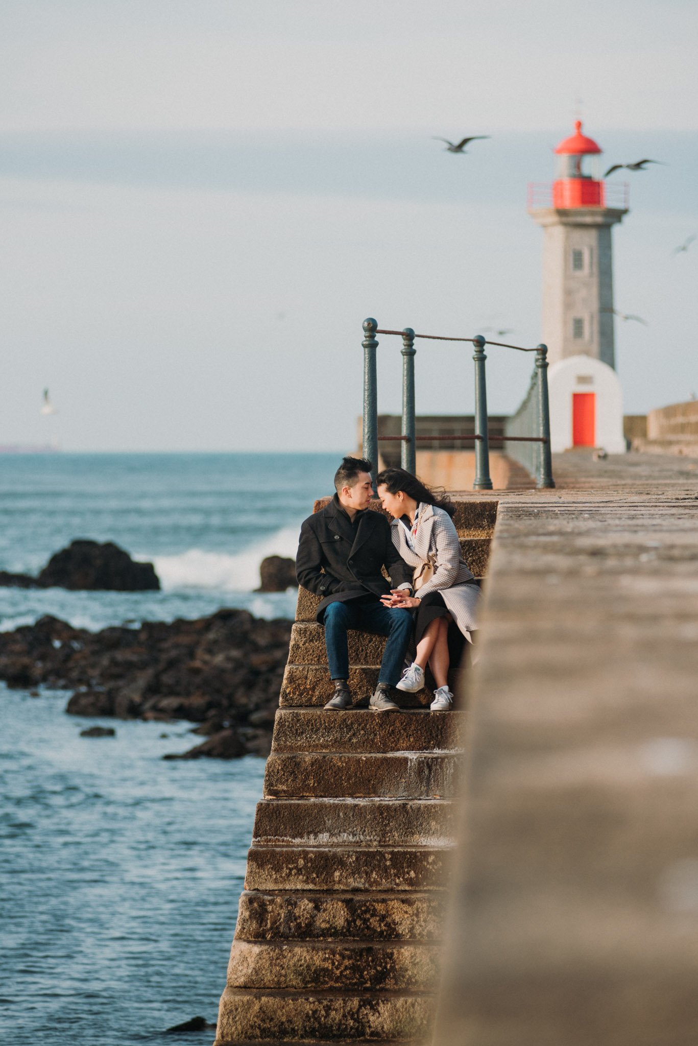 couple photoshoot at Foz do Douro lighthouse Porto with ocean and sunset light